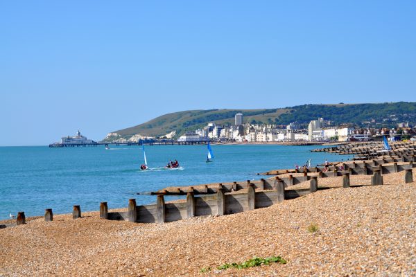 A pier in the background of a shingle beach