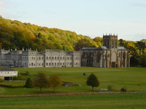 An abbey surrounded by woodland and landscaped gardens