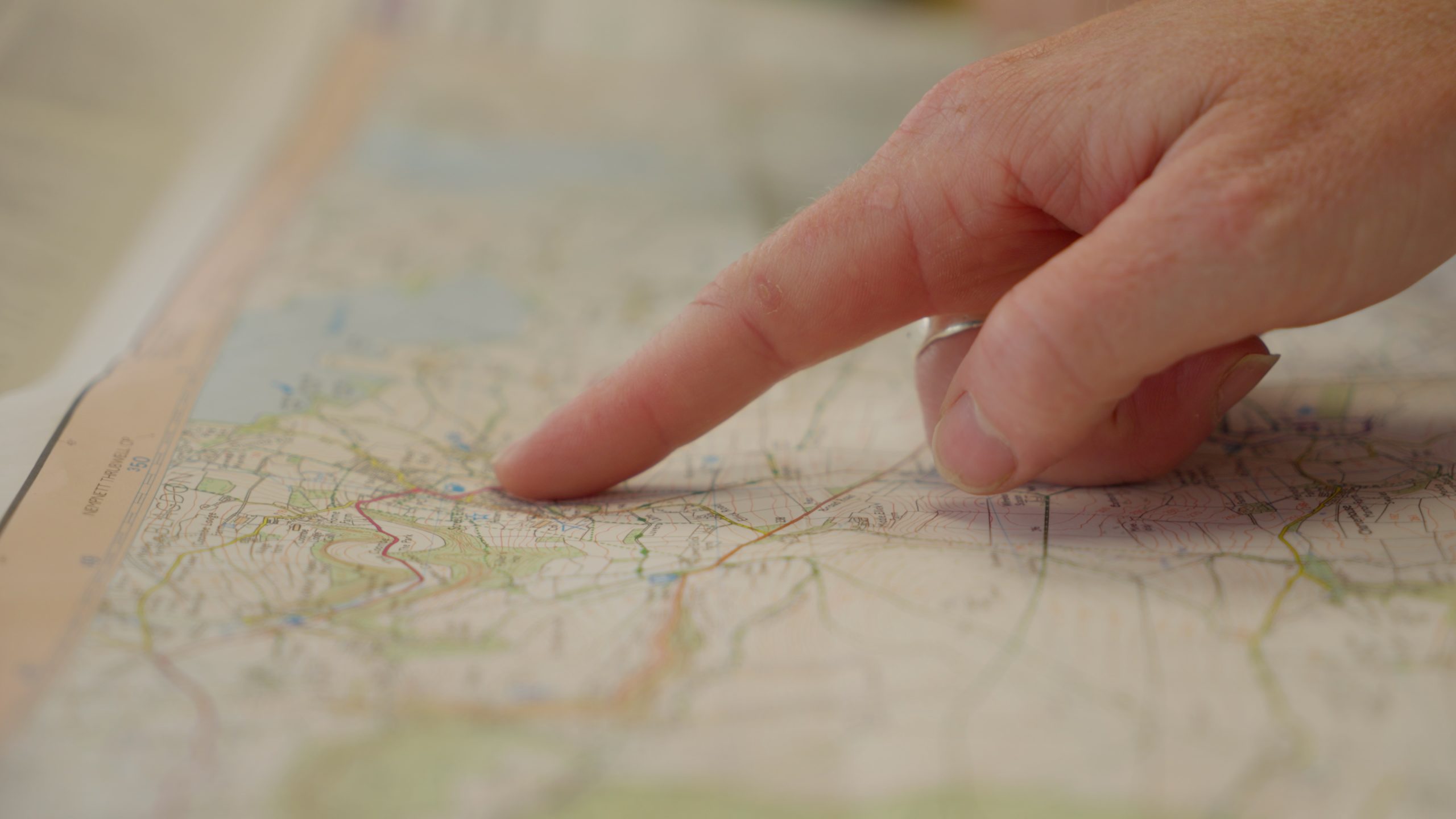 Finger pointing at map